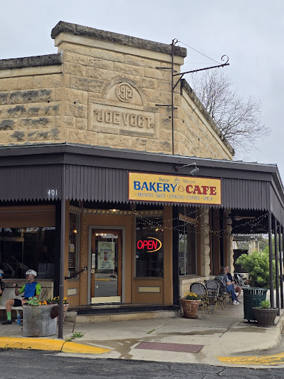 Bear Moon Bakery & Cafe Historic Stone Building Entrance Exterior of Bear Moon Bakery & Cafe, located in a historic stone building with an awning, outdoor seating, and a prominent "OPEN" sign.